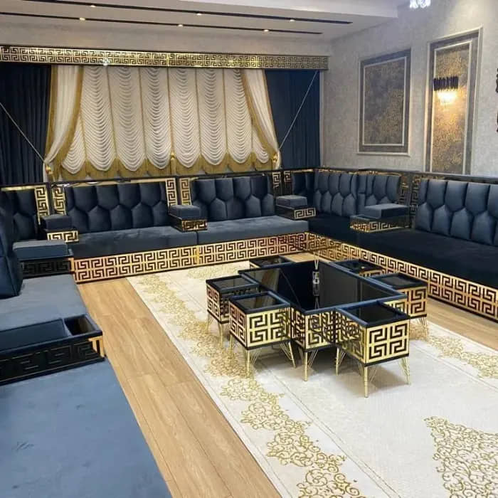 A-stylish-black-and-gold-majlis-sofa-featuring-plush-seating-decorative-throw-pillows-and-a-unique-coffee-table-setup-1
